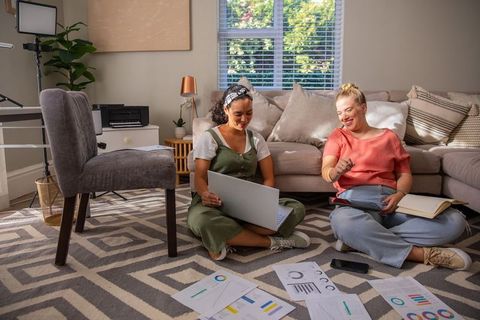 Diverse Friends Collaborating with Charts and Technology at Home