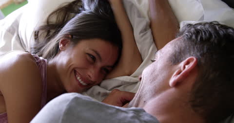 Caucasian Couple Smiling and Relaxing on Bed
