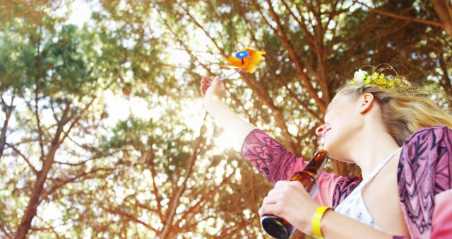 Young Woman Enjoying Outdoor Festival with Beer and Toy Parrot Under Trees - Download Free Stock Images Pikwizard.com