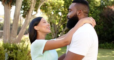Loving Couple Embracing in Sunlit Backyard Garden Serenity