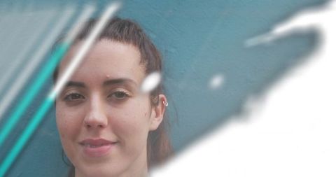 Serene woman smiling against teal wall with diagonal motion streaks and ear cuff closeup