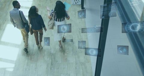 Business team walking through modern lobby with floating digital interface panels