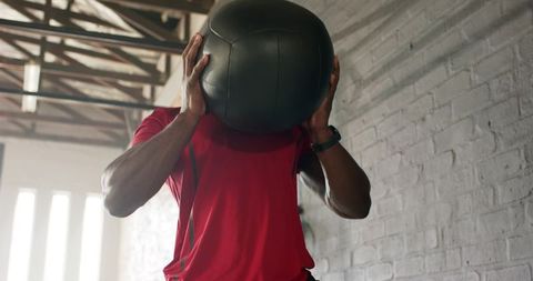 Man Lifting Medicine Ball in Urban Gym Environment
