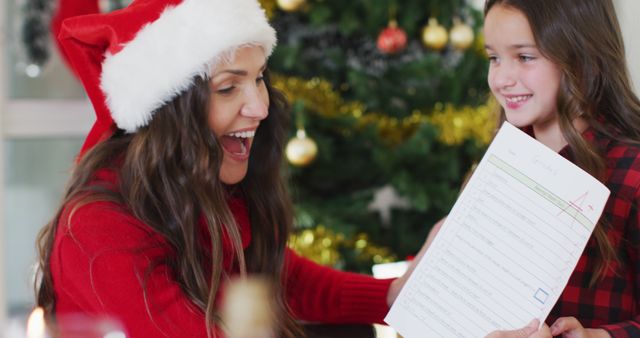 Mom Cheering with Christmas Homework Checklist by Christmas Tree - Download Free Stock Images Pikwizard.com