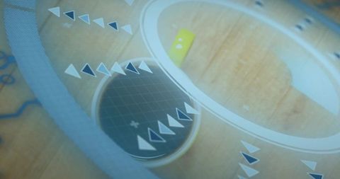 Futuristic circular interface overlay on wooden workspace with spinning grid disc and arrows