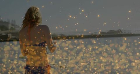 Woman in Blue Bikini at Seaside with Bokeh Overlay during Sunset
