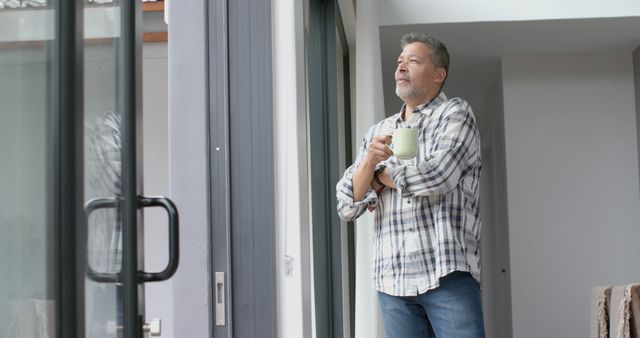 Mature Man Drinking Coffee and Relaxing by Window at Home - Download Free Stock Images Pikwizard.com