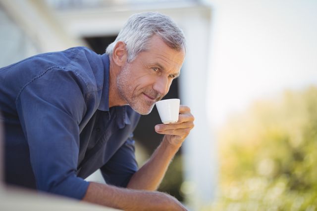 Mature man having coffee in balcony at home