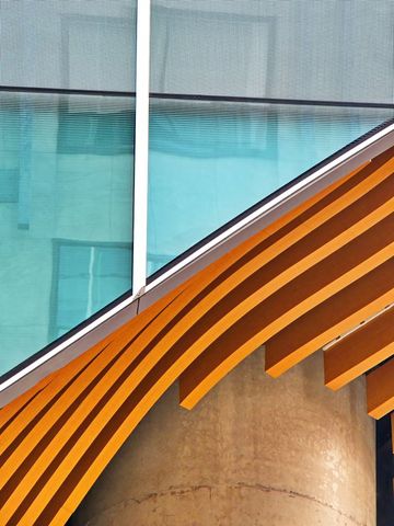 Modern architectural detail featuring wooden beams and glass facade