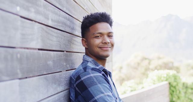 Confident Young Man Leaning Against Wooden Wall Outdoors - Download Free Stock Images Pikwizard.com