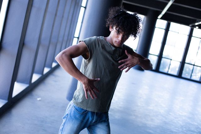 Transgender man dancing in an empty parking garage, expressing gender identity and diversity. Ideal for use in campaigns promoting gender expression, individuality, and urban lifestyle. Suitable for articles on contemporary dance, freedom of movement, and personal stories of identity.