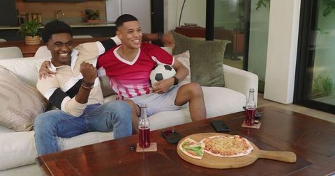 Enthusiastic Friends Enjoying Soccer Match at Home