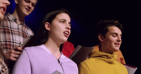 Teenage Choir Singers Rehearsing for Performance in Theatre