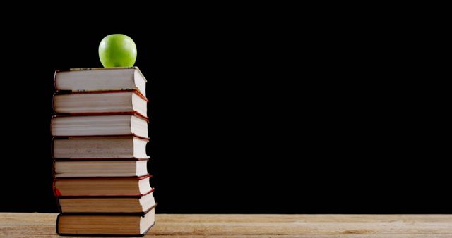 Stack of Books with Green Apple Against Black Background - Download Free Stock Images Pikwizard.com