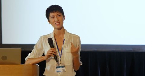 Confident Asian Speaker Presenting in Business Seminar