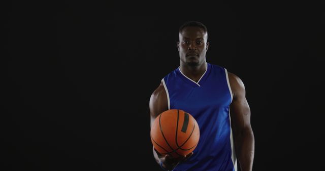 Serious Basketball Player Holding Ball on Dark Background - Download Free Stock Images Pikwizard.com