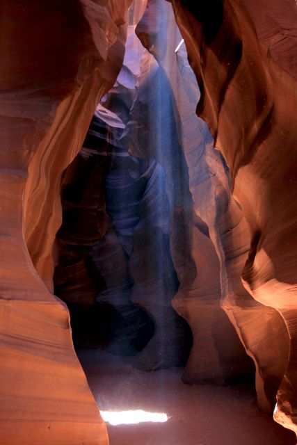 Sunlight beams down through the narrow openings of Antelope Canyon, illuminating the smooth sandstone walls. This breathtaking image captures the natural beauty and unique formations of the slot canyon. Ideal for use in travel brochures, nature photography collections, or as decorative artwork celebrating the wonders of the natural world.