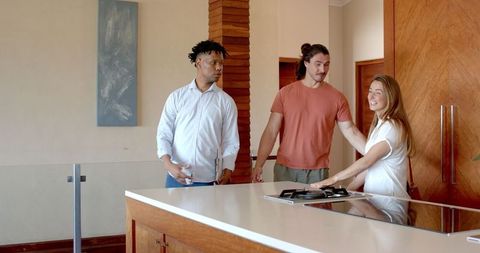 Friends Exploring Modern Kitchen in Welcoming Environment