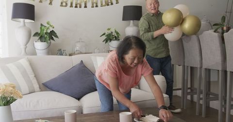 Senior Couple Preparing for Birthday Celebration with Balloons