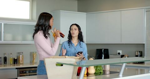 Female Friends Discussing Recipe in Modern Kitchen