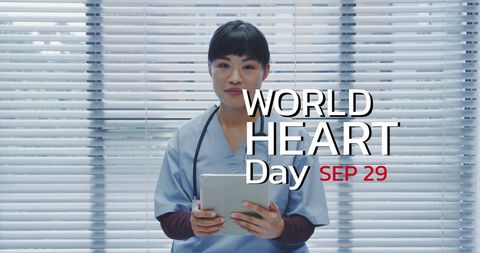 Asian Nurse Promotes World Heart Day With Tablet and Scrubs