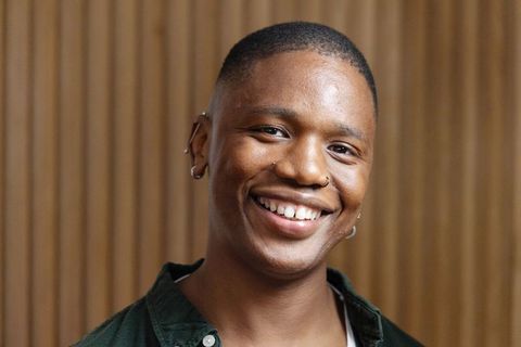 Confident african american man smiling closeup with nose ring and ear piercings