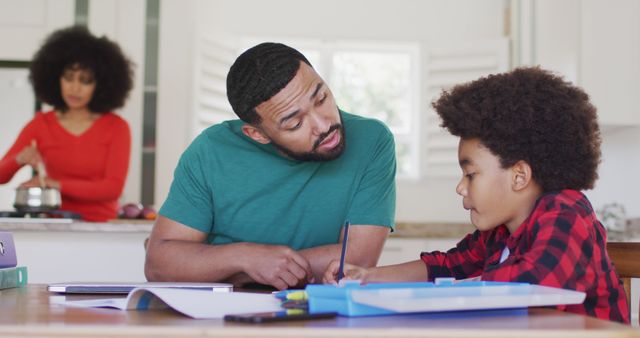 Father Helping Son with Homework While Mother Cooking in Background - Download Free Stock Images Pikwizard.com