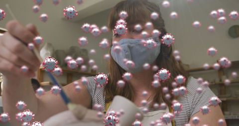 Masked Artisan Creating Pottery in Workshop