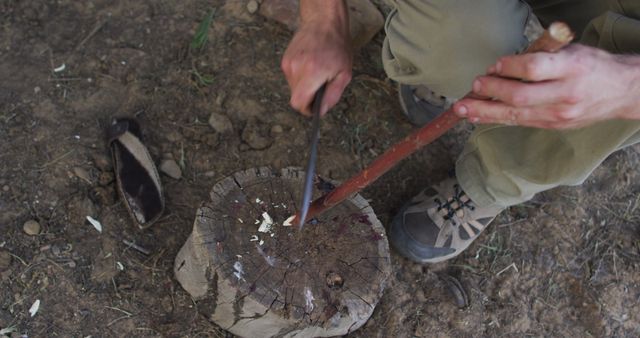 Person whittling wooden stick with knife on stump outdoors - Download Free Stock Images Pikwizard.com