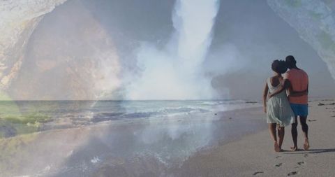 Walking couple embracing on pastel shoreline with waterfall double exposure