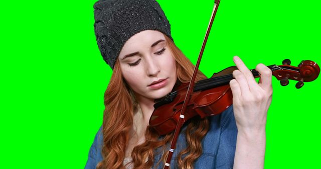 Close-up of female musician playing violin against green screen