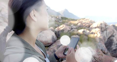 Woman Exploring Scenic Coastline Holding Smartphone