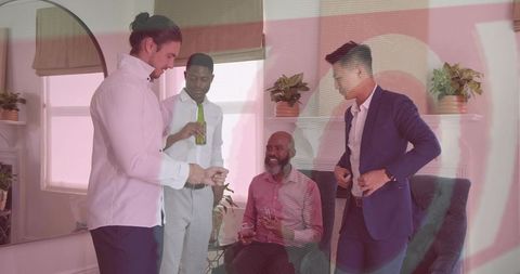 Young professionals socializing in modern living room, holding drinks, informal networking