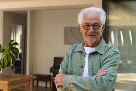 Senior man wearing eyeglasses standing in modern living room