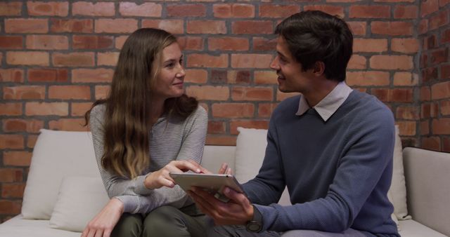 Two Young Professionals Discussing Work on Tablet in Modern Office - Download Free Stock Images Pikwizard.com