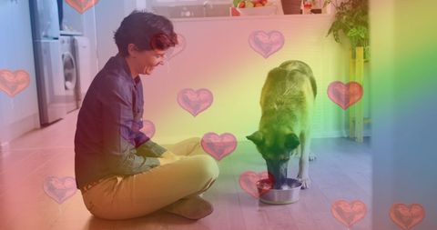 Caucasian Woman Feeding Dog with Rainbow and Heart Overlay