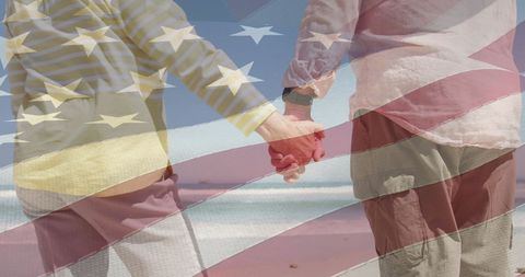 Senior Couple Holding Hands on Beach Against American Flag