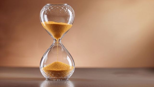 Golden sand flowing through elegant hourglass