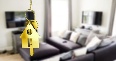 Golden house keychain and modern living room background