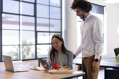 Coworkers Bonding Over Gift Exchange in Modern Office