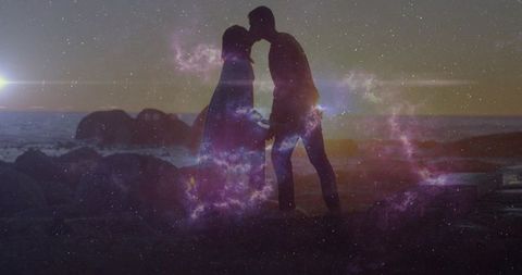 Silhouetted couple sharing romantic kiss with celestial nebula effect