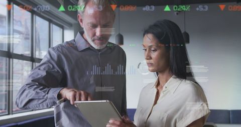 Business Professionals Analyzing Data on Digital Tablet in Modern Office