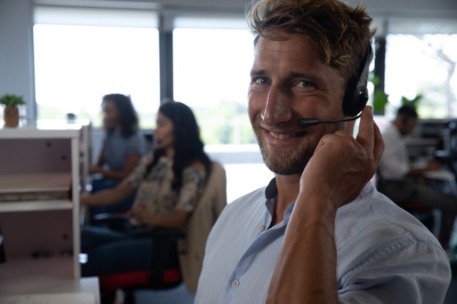 Smiling Businessman Wearing Headset in Modern Office - Download Free Stock Images Pikwizard.com