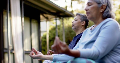 Senior Couple Meditating Outdoors in Tranquil Garden