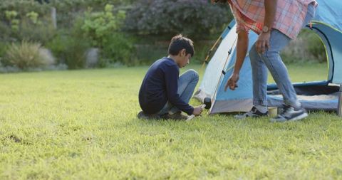 Father and Son Setting Up Tent in Outdoor Garden Adventure
