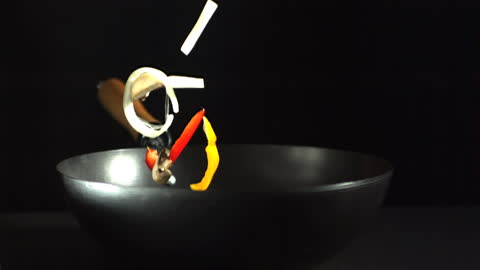 Assorted Vegetables Falling into Wok in Demonstation on Culinary Art