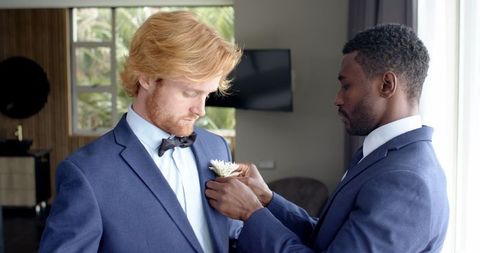 Groom and best man preparing for wedding ceremony in elegant room