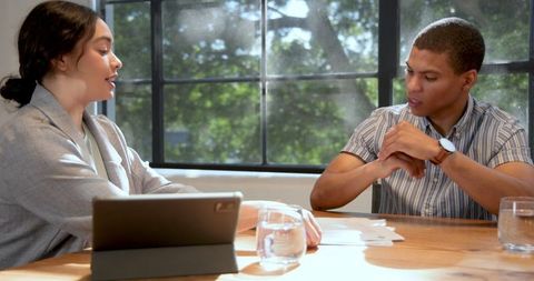 Collaborative business meeting with document signing in sunny office