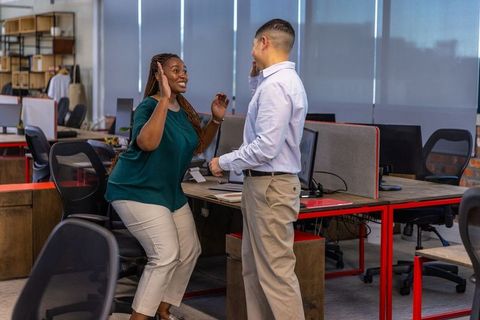 Diverse Coworkers Celebrating Success with a High Five in Office