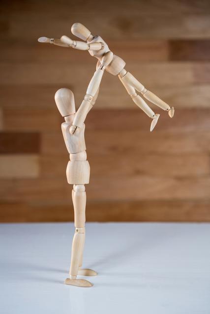 Conceptual image of figurine lifting baby figurine